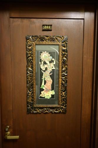 a door with a picture of a woman on it at Hotel Bali Moon in Toi