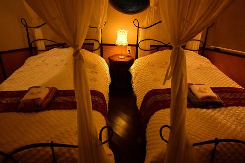 two twin beds in a bedroom with a lamp at Hotel Bali Moon in Toi