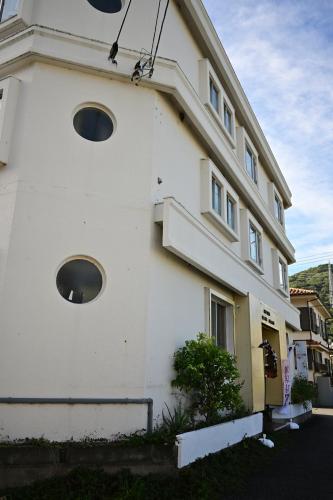 a white building with round windows on the side of it at Hotel Bali Moon in Toi