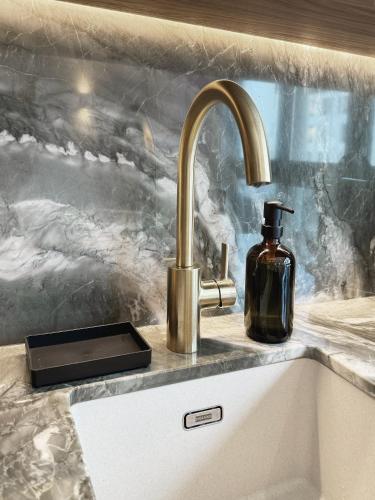 un évier de cuisine avec un distributeur de savon à côté d'un évier dans l'établissement TheSuite - Parmentier - MONTHLY RENTAL ONLY, à Paris