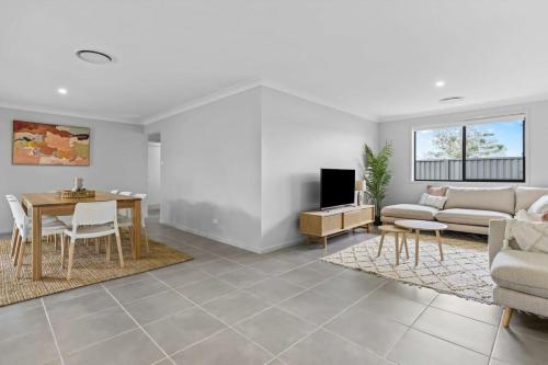 a living room with a couch and a table at Time Out Beautifully decorated new home in Cessnock