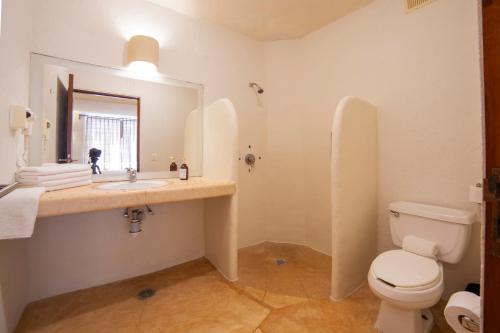 a bathroom with a sink and a toilet and a mirror at HOTEL BIULÚ in Santa Cruz Huatulco
