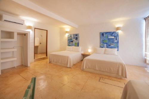 a large room with two beds and a room with at HOTEL BIULÚ in Santa Cruz Huatulco
