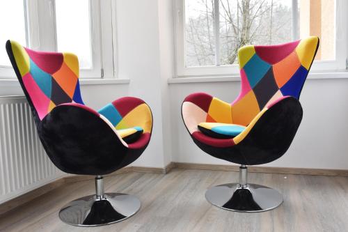 two colorful chairs sitting in a room at Vila Tanvald s wellness a wallboxem in Tanvald