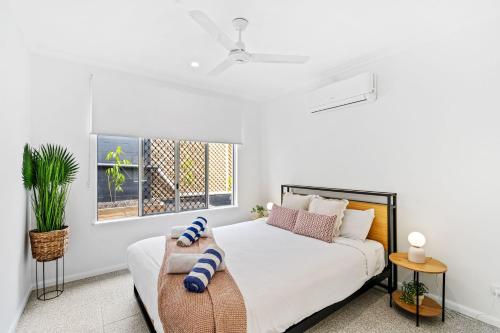 a white bedroom with a bed and a window at Belle Escapes Mer-Sea in Trinity Beach