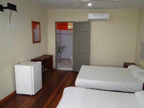 a room with two beds and a bathroom at Hotel Nitana in Coveñas