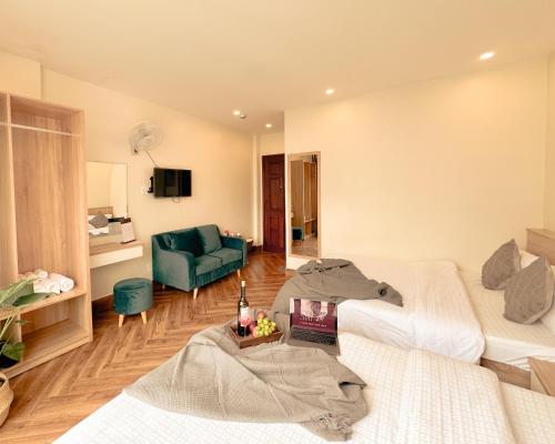 a living room with two beds and a green couch at L'amour Stay Dalat in Xuan An