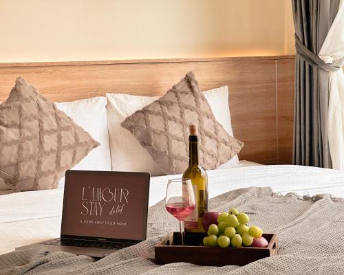 a bottle of wine and a tray of grapes on a bed at L'amour Stay Dalat in Xuan An