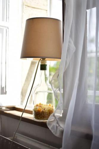 une bouteille assise sur un rebord de fenêtre avec une lampe dans l'établissement La Villa Marie Vue imprenable, à Carnac