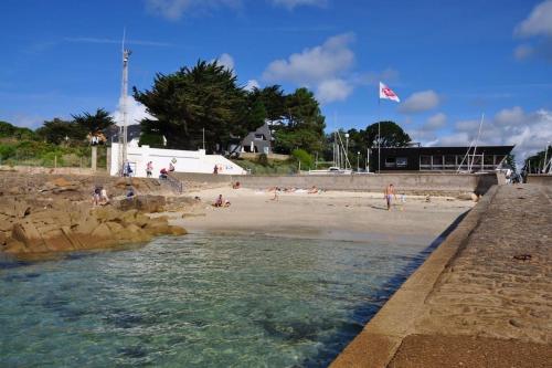 une plage avec des gens sur le sable et un drapeau dans l'établissement La Villa Marie Vue imprenable, à Carnac