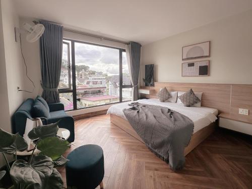 a bedroom with a bed and a large window at L'amour Stay Dalat in Xuan An