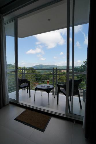 a room with a balcony with a table and chairs at Regent Heights in Kandy
