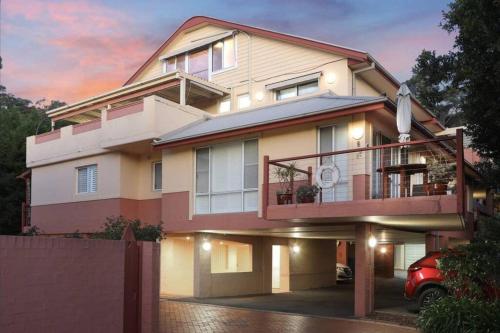 una casa con un coche aparcado delante en Magical Hardy's Bay Waterfront Apartment, en Killcare