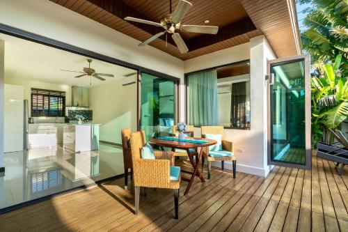 a dining room and living room with a ceiling fan at Sanook dream villas Nai Harn Beach in Rawai Beach