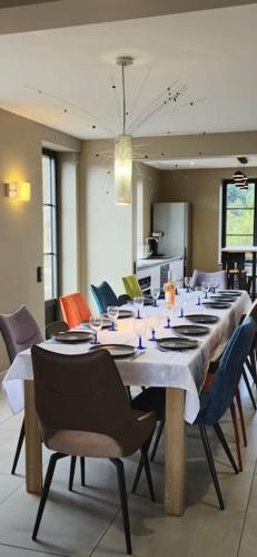 une grande salle à manger avec une longue table et des chaises dans l'établissement La Maison Saint-Amour, à Chanaleilles