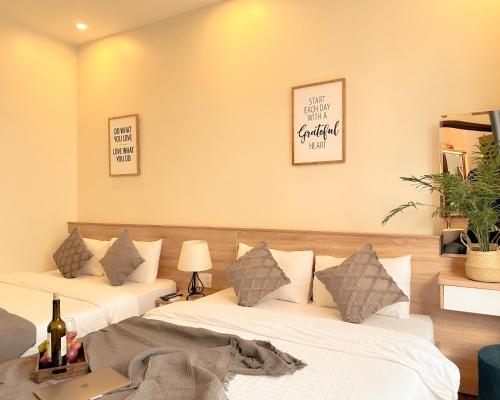 two beds in a room with two lamps at L'amour Stay Dalat in Xuan An