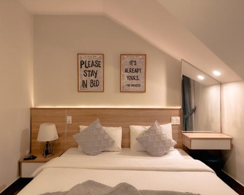 a bedroom with a bed with two pictures on the wall at L'amour Stay Dalat in Xuan An