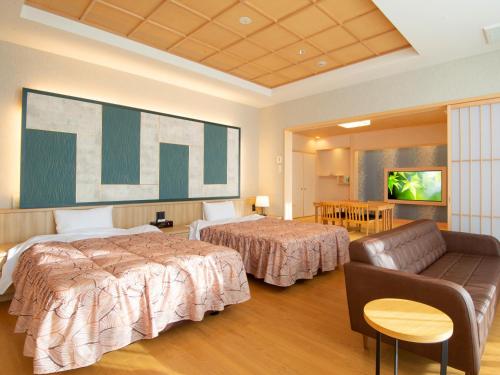 a hotel room with two beds and a couch at 河内長野荘 in Nagano