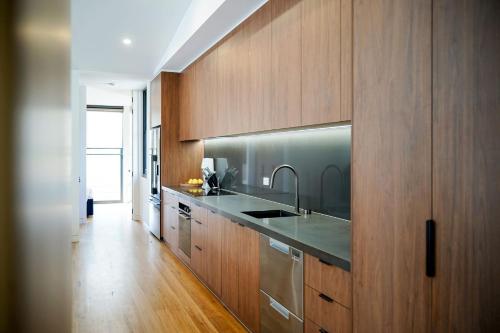 a kitchen with a sink and wooden cabinets at Banjo Treehouse in Hepburn Springs