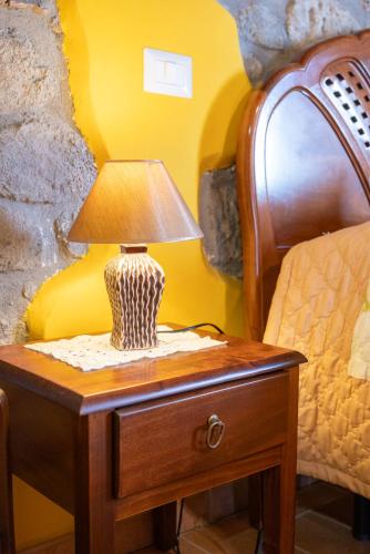 a lamp on a table next to a bed at appartamento LE LOGGE in Montefiascone