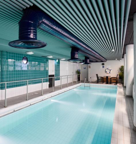 a large swimming pool in a building with a pool at Hostel Linnasmäki in Turku
