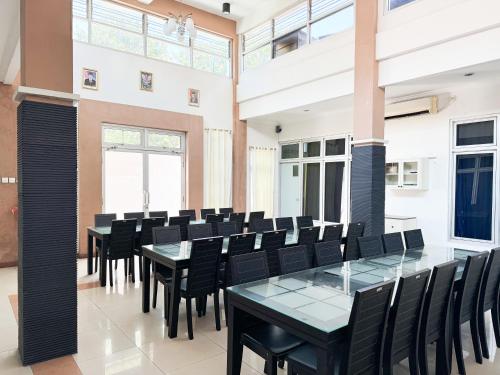 a conference room with black chairs and a glass table at RedDoorz at Politeknik Pelayaran Surabaya in Surabaya