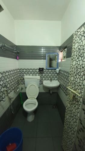 a bathroom with a toilet and a sink at MIG Bliss in Fort Kochi