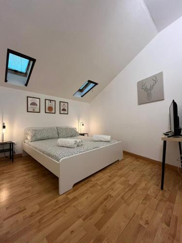 a white bedroom with a bed and a television at Fikus APT relax Castello Ursino in Catania