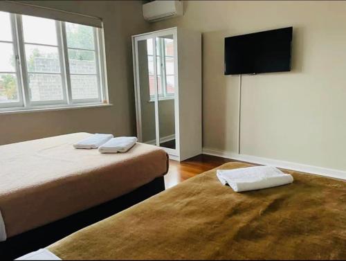 a bedroom with two beds and a flat screen tv at Executive Central Escape on Throssel in Collie
