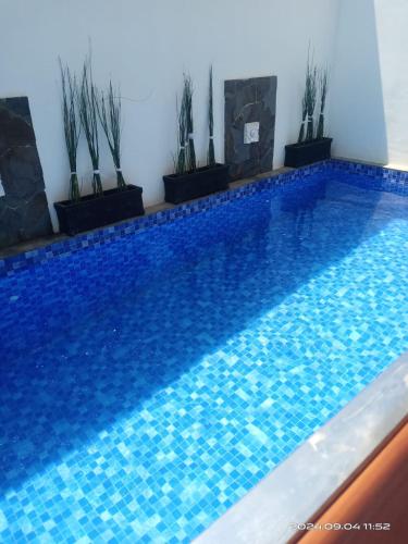 a blue swimming pool with plants on the side at Villa Naratetama in Batu