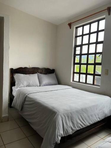 a bedroom with a large bed with a window at excelente casa inka con cochera en el centro in San Cristóbal de Las Casas