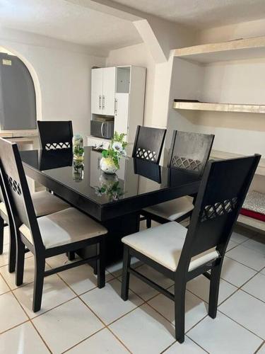 a dining room with a black table and chairs at excelente casa inka con cochera en el centro in San Cristóbal de Las Casas