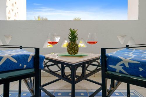 a table with a pineapple and two glasses of wine at Domina Coral Bay Resort, Diving , Spa & Casino in Sharm El Sheikh