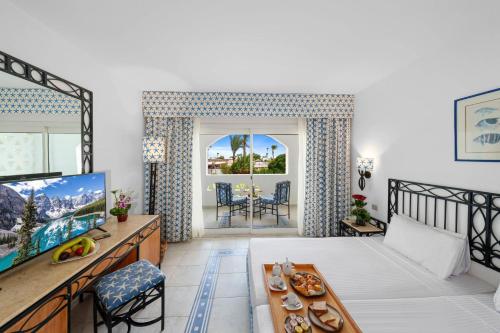 a living room with a couch and a tv at Domina Coral Bay Resort, Diving , Spa & Casino in Sharm El Sheikh