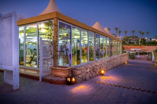 a large building with glass windows and lights at Domina Coral Bay Resort, Diving , Spa & Casino in Sharm El Sheikh