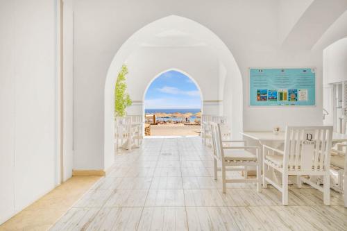 a dining room with an archway and a table and chairs at Domina Coral Bay Resort, Diving , Spa & Casino in Sharm El Sheikh