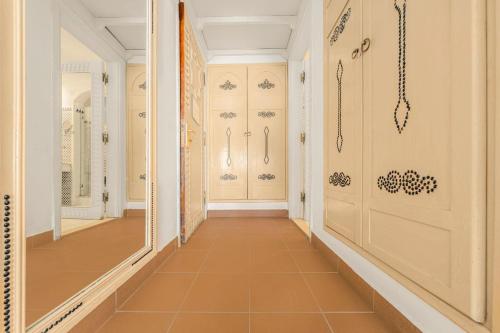a hallway with white doors and orange tile floors at Domina Coral Bay Resort, Diving , Spa & Casino in Sharm El Sheikh