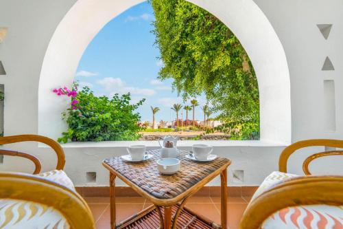 a table and chairs on a balcony with a window at Domina Coral Bay Resort, Diving , Spa & Casino in Sharm El Sheikh