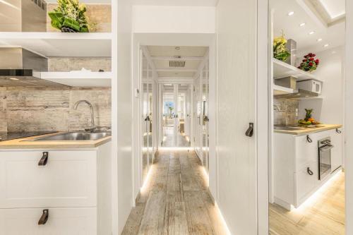 a kitchen with white cabinets and a wooden floor at Domina Coral Bay Resort, Diving , Spa & Casino in Sharm El Sheikh