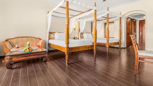 a bedroom with two beds and a couch and a table at Domina Coral Bay Resort, Diving , Spa & Casino in Sharm El Sheikh