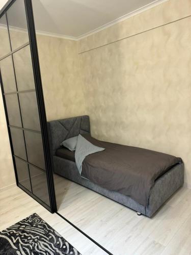 a bed in a room with a mirror at Apartment in Airport in (( Turksib ))