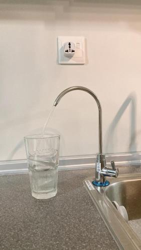a glass of water sitting next to a kitchen sink at Mango House5-High floor I Biggest unit I Sea view l Mountain view I Waterfilter I Wifi-JQ in Kota Kinabalu