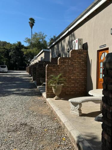 a bench sitting on a sidewalk next to a building at The Palms Venue & Accommodation in Cradock