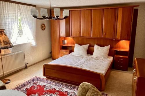 una camera da letto con un letto grande con armadi in legno di Vintage Haus AUF DEM HEIDCHEN mit Sauna a Knüllwald