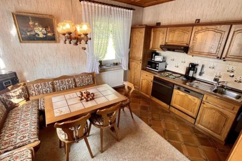 un soggiorno con tavolo e cucina di Vintage Haus AUF DEM HEIDCHEN mit Sauna a Knüllwald