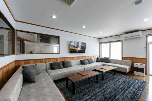 a living room with a large couch and a table at The North Peak Nakafurano in Nakafurano