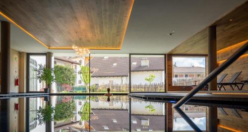 a house with a pool in the middle of a building at Schwarzer Adler in Siusi