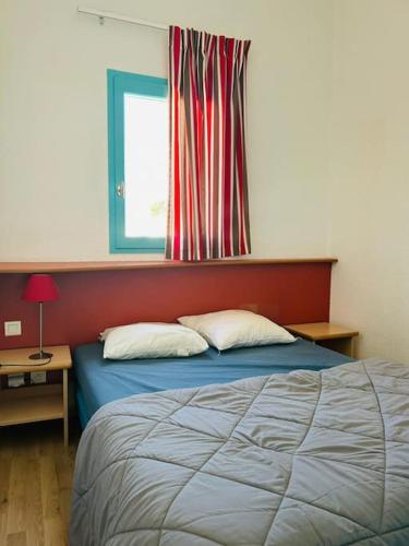 Cette chambre comprend un lit avec deux oreillers et une fenêtre. dans l'établissement Charmante maisonnette, à Argelès-sur-Mer