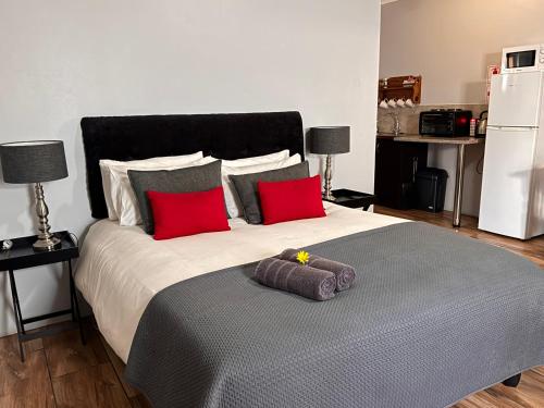 a bedroom with a large bed with red pillows at The Palms Venue & Accommodation in Cradock