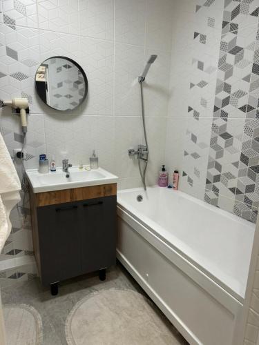 a bathroom with a sink and a tub and a mirror at Apartment in Airport in (( Turksib ))